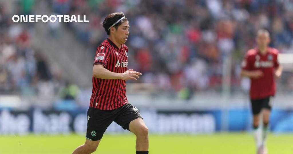 Pemain sayap Hannover 96 Daisuke Yokota sedang melakukan sesi latihan di lapangan dengan mengenakan jersey klub berwarna merah.