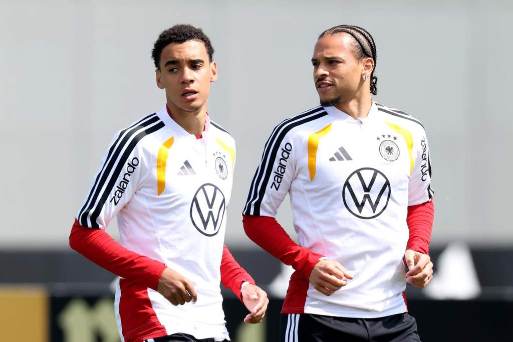 Para pemain Timnas Jerman berbaris di lapangan hijau mengenakan jersey kebesaran menjelang pertandingan internasional.