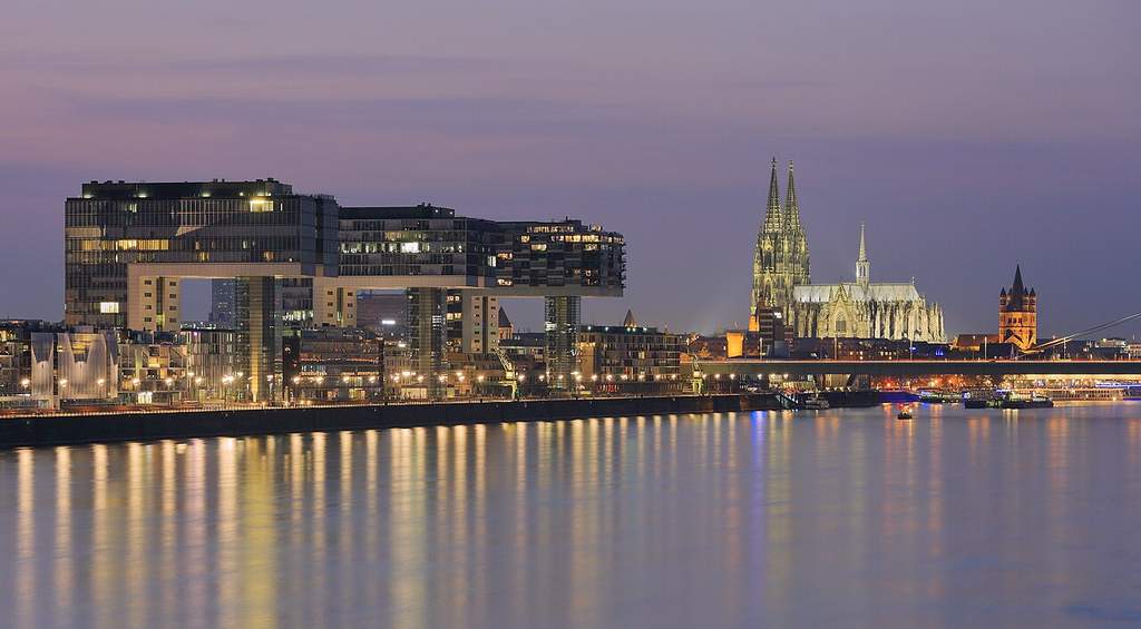 Pemandangan Kota Cologne di tepi Sungai Rhein dengan latar megahnya bangunan Katedral Cologne yang ikonik dan bersejarah.