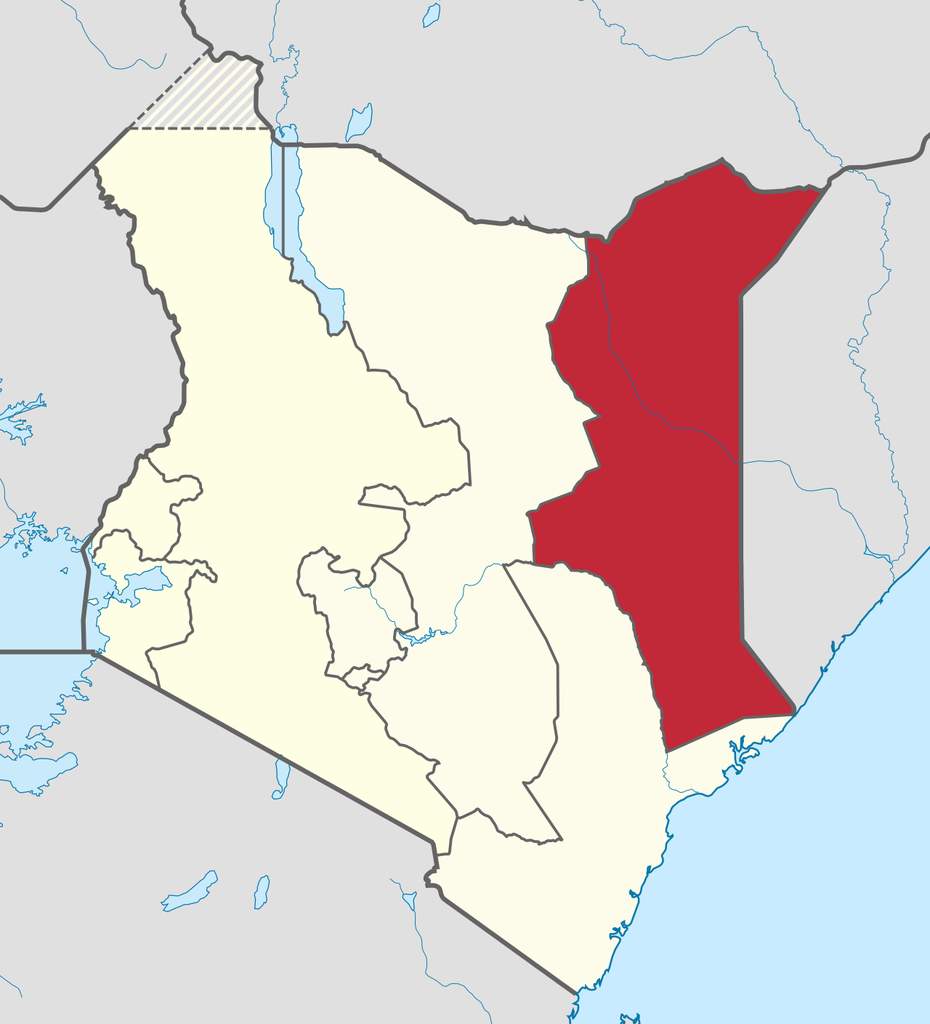 Pemandangan lanskap semi-arid dan kawasan permukiman di wilayah North Eastern Province, Kenya, dengan latar belakang padang savana.